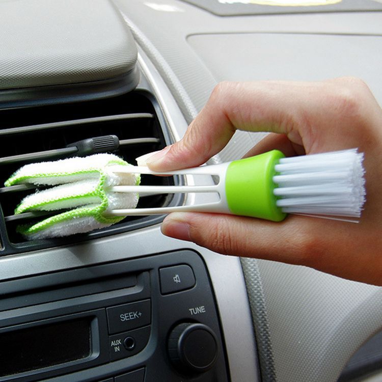 Person holding a Double Head Cleaning Brush for effective dusting in a car interior.