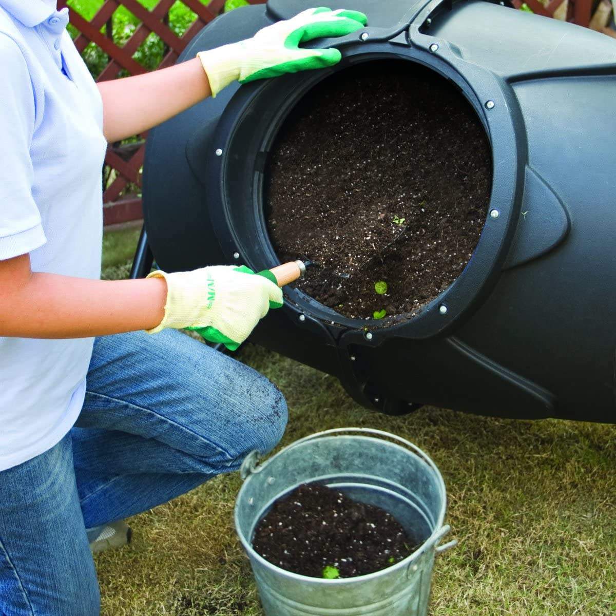 Person adding kitchen waste into a Removable Rotary Compost Bucket for efficient composting in a garden.