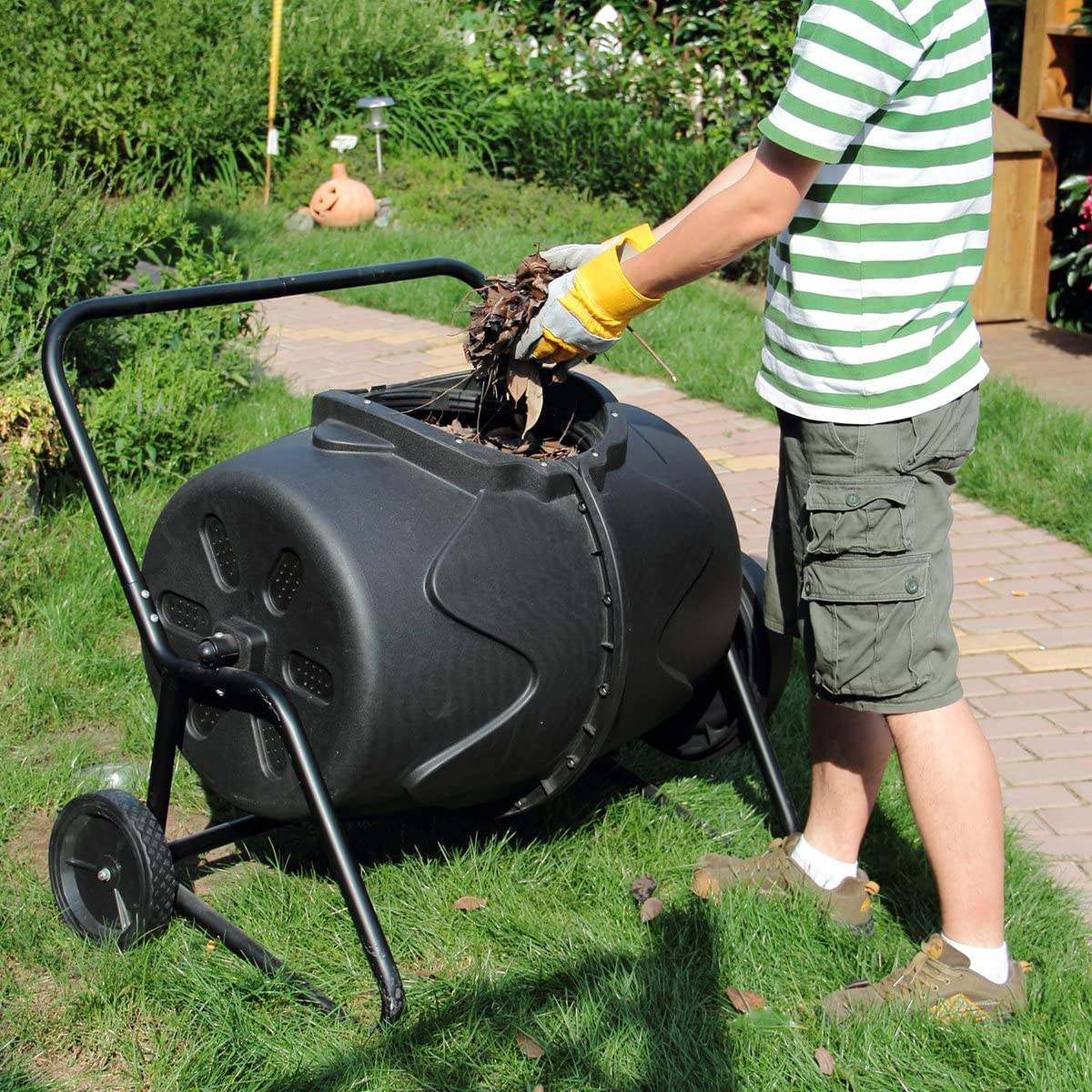 Person adding kitchen waste into a Removable Rotary Compost Bucket for efficient composting in a garden.