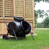 Person adding kitchen waste into a Removable Rotary Compost Bucket for efficient composting in a garden.