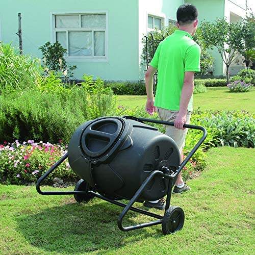 Person adding kitchen waste into a Removable Rotary Compost Bucket for efficient composting in a garden.