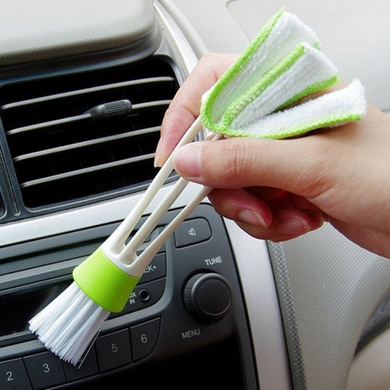 Person holding a Double Head Cleaning Brush for effective dusting in a car interior.